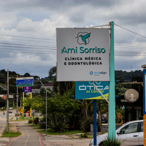 Fachada da clínica Ami Sorriso em Campo Magro, com placa identificando a especialização em clínica médica e odontológica.